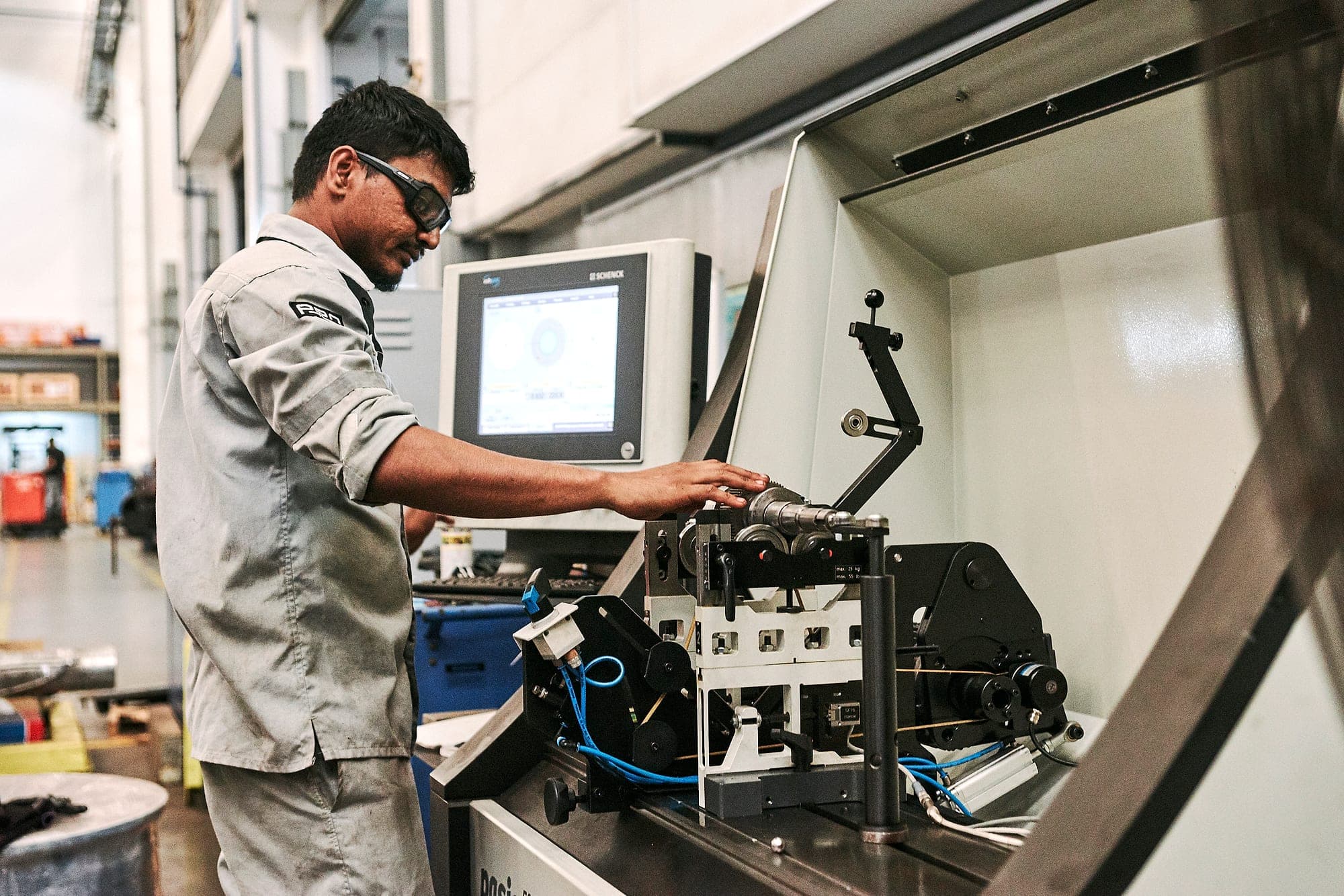 Exion technician operating the Schenck dynamic balancing machine in the rotating workshop