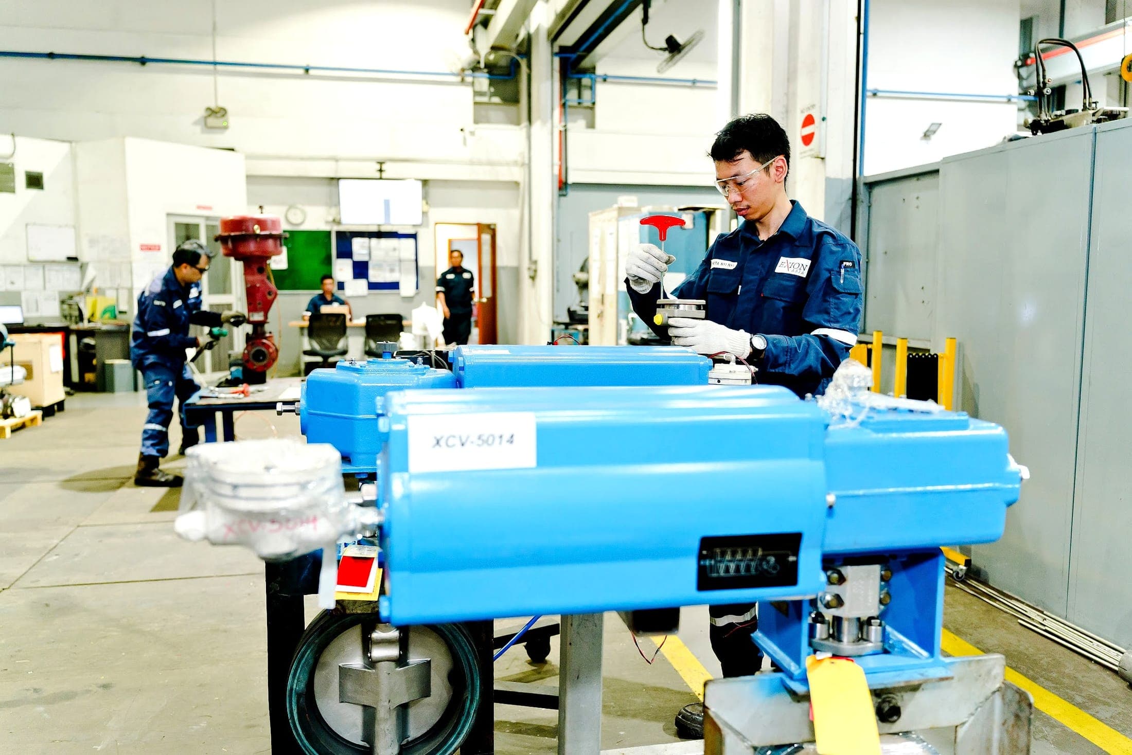 Exion technician servicing pneumatic actuated control valves in the flow control workshop
