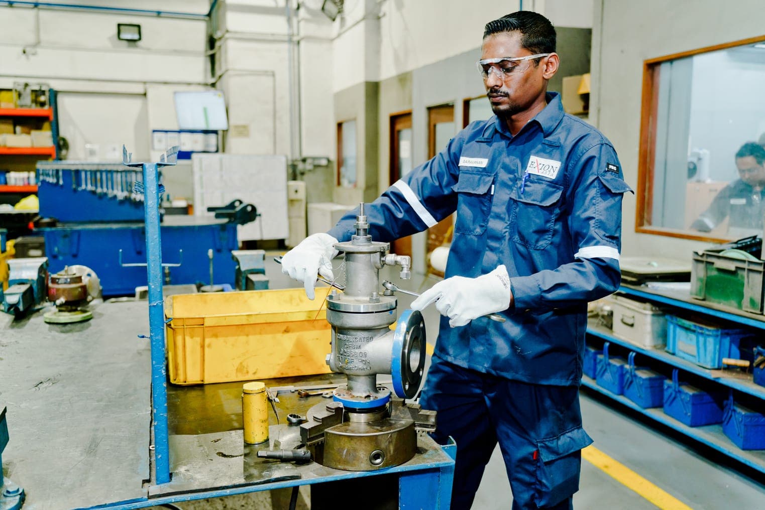 Exion technician setting a safety relief valve on the workshop test bench