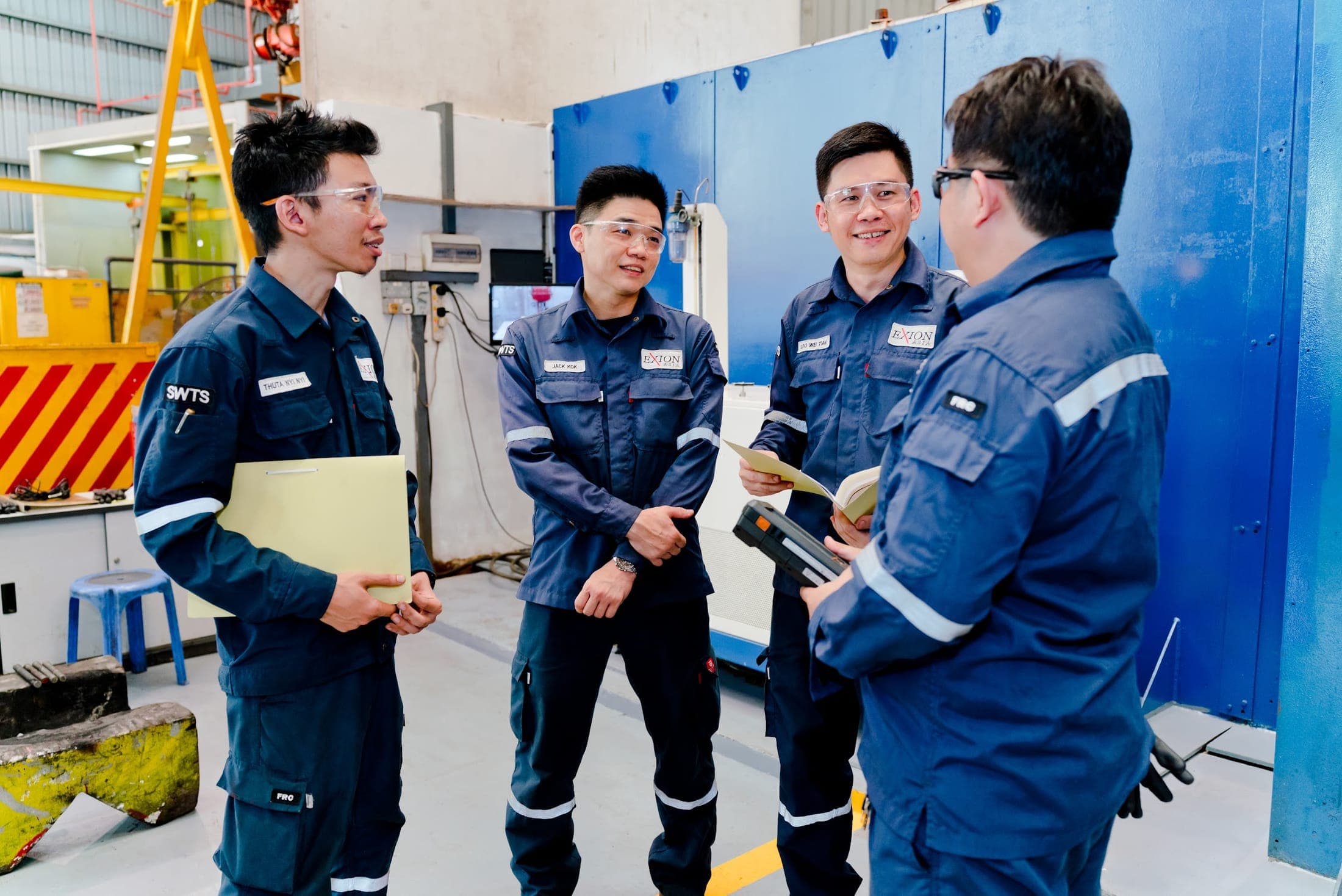 Exion engineers discussing a job in front of the CNC machining centre