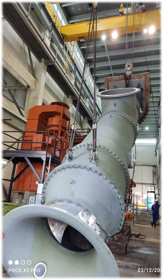 Large vertical centrifugal pump lifted by overhead crane in the Exion workshop
