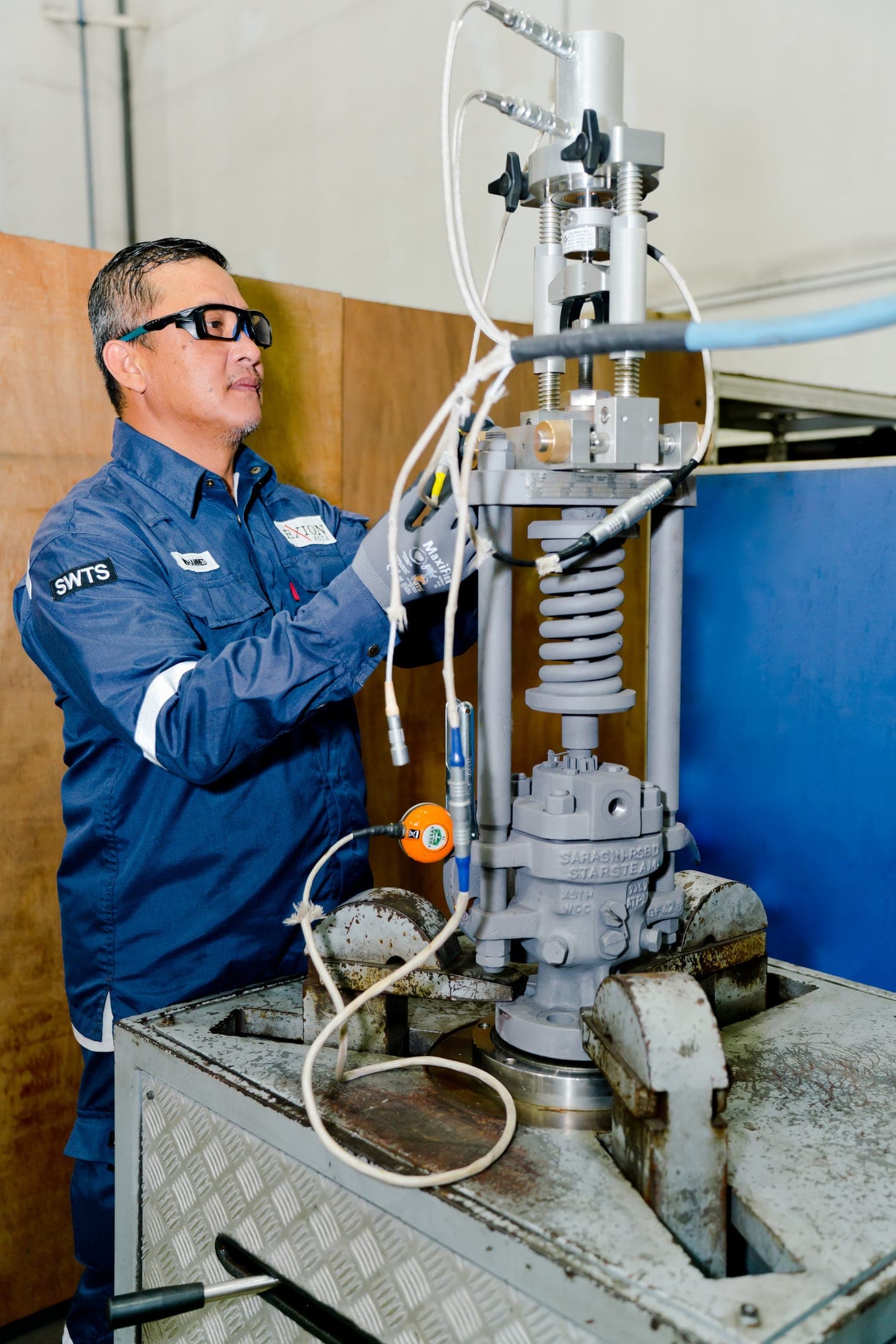 Exion technician setting a safety valve on the workshop test bench